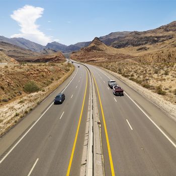 Birds eye view of automobiles on rural desert highway.