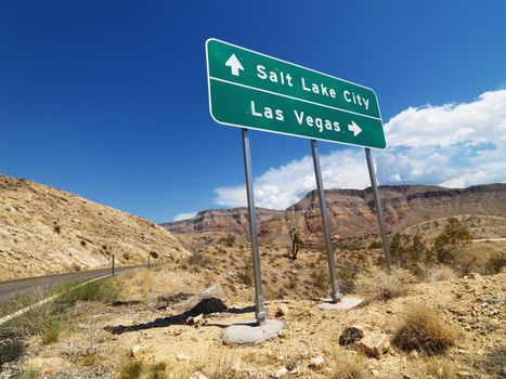 Road sign in desert pointing towards Salt Lake City and Las Vegas.