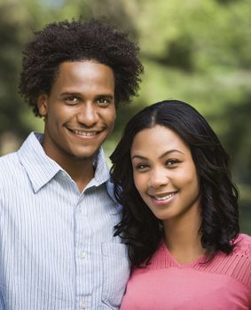 Head and shoulder portrait of smiling couple in park.