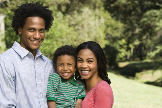 Family portrait of parents and young son smiling.