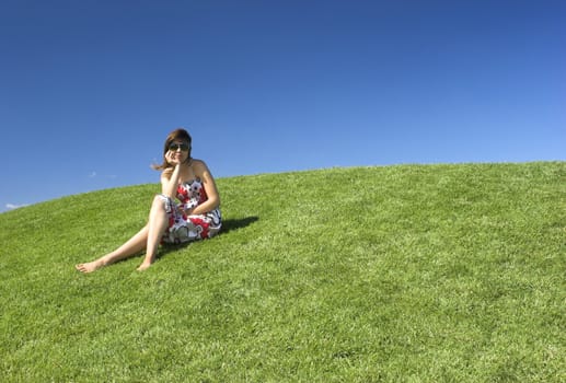 Beautiful woman relaxing on a beautiful green field