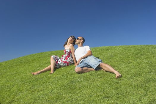 Beautiful couple of boyfriends relaxing on a beautiful green field