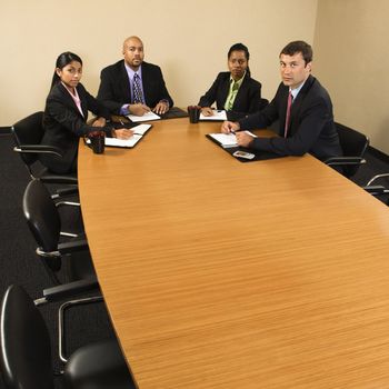 Businesspeople sitting at conference table.