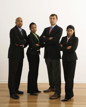 Portrait of businessmen and businesswomen standing with arms crossed looking serious.