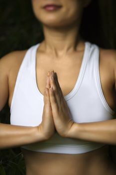 Portrait of Asian American woman in fitness attire standing in yoga position.