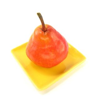 image of a red pear on a yellow plate