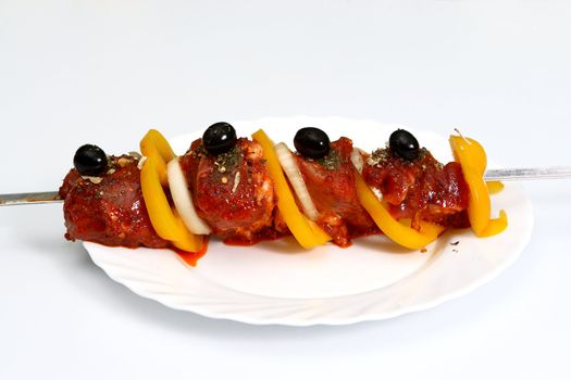 Crude shish kebab with pepper, an onions, olives and seasoning