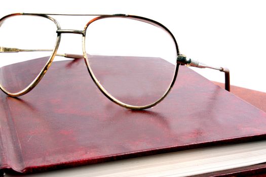 A metaphorical image showing reading glasses on a library book, a break from reading.