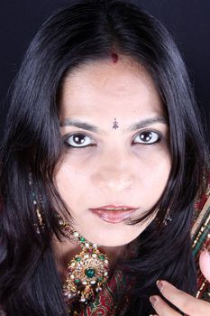 A potrait of a beautiful Indian woman in her traditional jewelery.