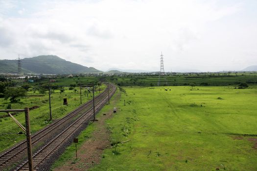 A railroad turning on a landscape of beautiful grasslands.