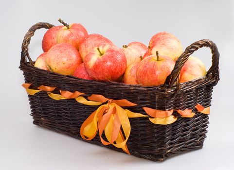 The basket with apples on the white background