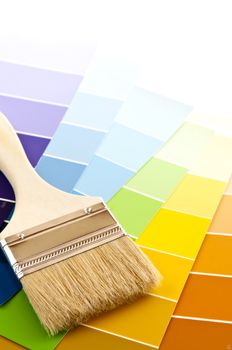 Clean paintbrush on rainbow of color card samples