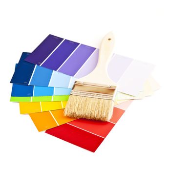 Clean paintbrush on rainbow of color card samples