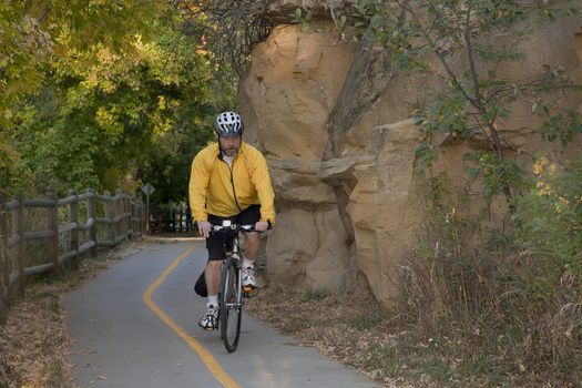 middle aged male riding a bike or commuting on biking trail, Poudre River Corridor Trail near Greeley, Colorado, fall scenery