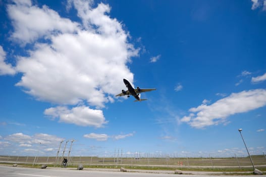 Plane is going to land. Blue and cloudy sky.