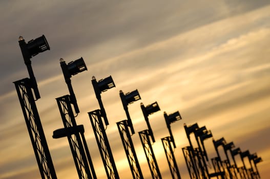 Line of landing lights and sunset at airport.