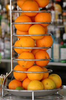 Many oranges in a special container at a bar counter