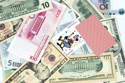 Mixed banknotes as background with two cards - jokers. Photo of different banknotes, money in different shapes and colors. Useful for financial, economic backgrounds.