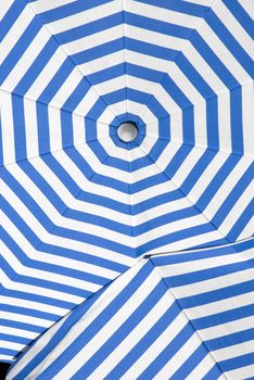 overlapping sun shade umbrellas with white and blue stripes