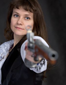 The girl - pirate with ancient pistol in hand on a black background