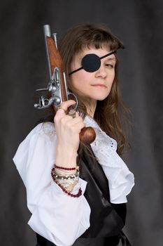 Girl - pirate with pistol in hand and eye patch on face