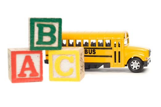 Concept image of elementary school using a toy school bus and baby letter blocks