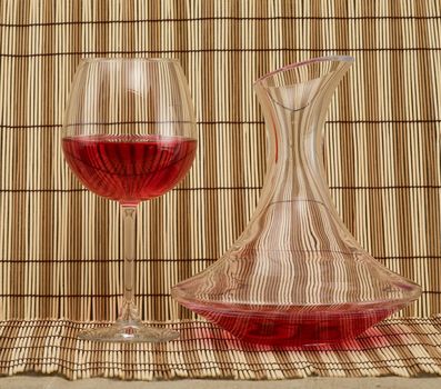 Stil life with decanter and goblet on mat