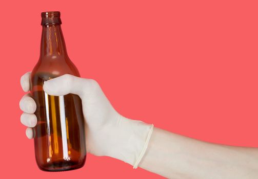 Brown bottle in hand on the red background
