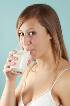 young caucasian woman drinkin a glass of fresh milk