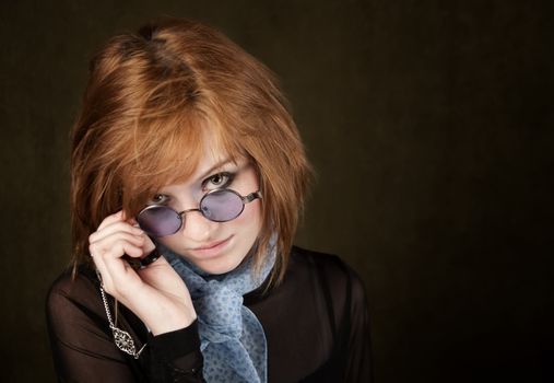 Pretty teenage girl with round blue sunglasses