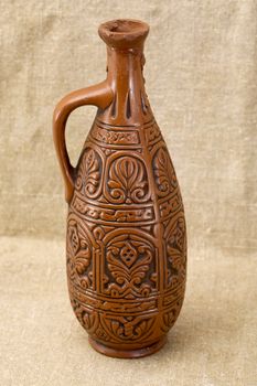 Ancient clay large bottle on fabric background