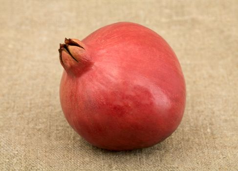 The pomegranate on the brown sacking background