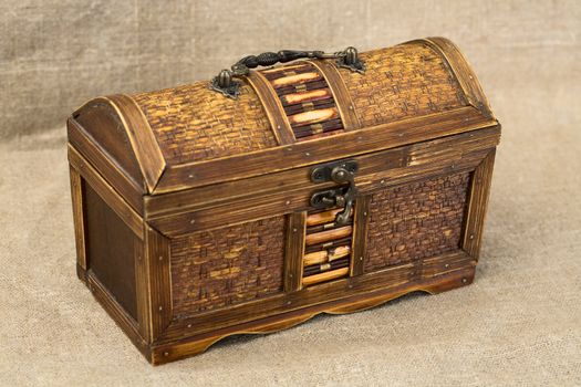 Wooden chest with iron handles on the sacking background