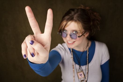 Pretty teen girl making a peace sign with her hand