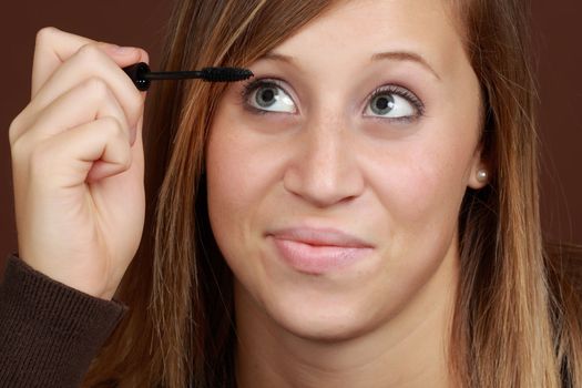 young caucasian woman applying mascara
