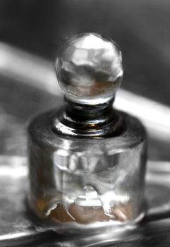 Glass bottle of perfumery in water with drops