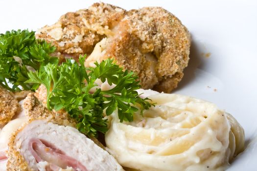 chicken cordon blue on a white plate breaded and close up