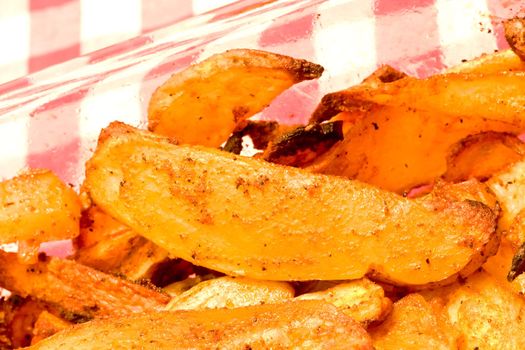 close up of seasoned french fries with a red checker napkin