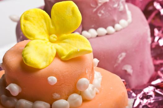 two small nicely decorated cakes yellow and pink 