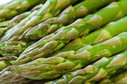 freshly washed still dripping with water close up of asparagus