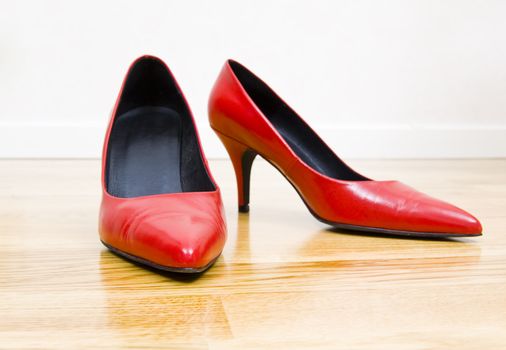 fashionable female shoes on wooden floor
