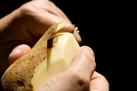 a women peeling a potato close up of the womens hands