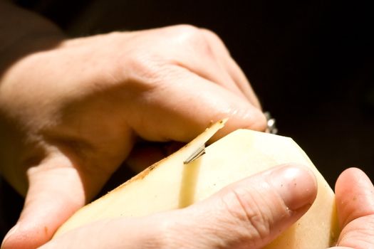 a women peeling a potato close up of the womens hands