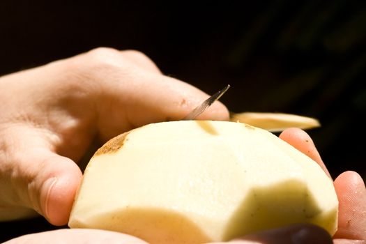 a women peeling a potato close up of the womens hands