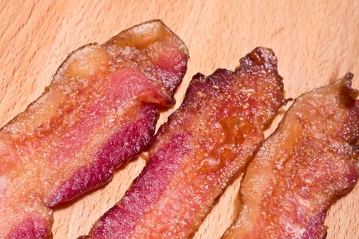 slices of cooked bacon on a wood cutting board