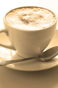 Cup of hot cappuccino, close-up. Image tinted