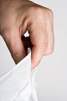 womens hand grabbing a tissue out of the box on a off white background