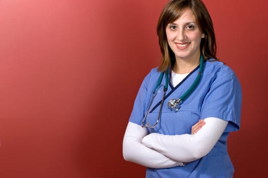 A young woman doctor with her arms crossed isolated over a red background