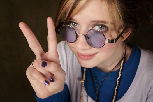 Pretty teen girl making a peace sign with her hand