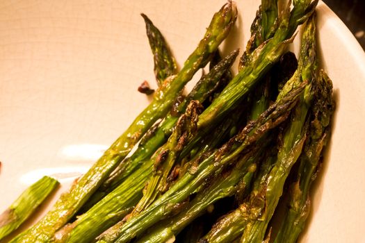 hot asparagus baked in an oven coated with oil salt and pepper